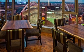 a restaurant with a view of a stadium and tables and chairs